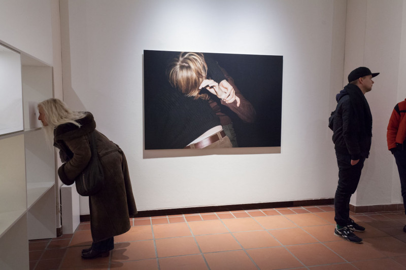 Besucher betrachten die Ausstellung. An der Wand hängt ein großes Foto.