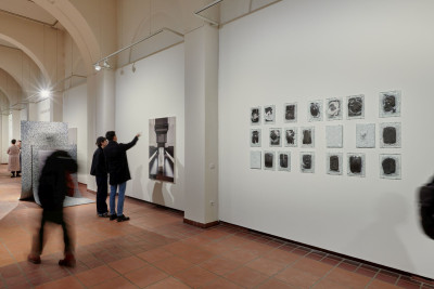 Innenraum der Galerie im Körnerpark mit Besuchern, Skulpturen auf dem Boden und Kunstwerken an den Wänden