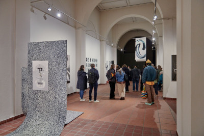 Innenraum der Galerie im Körnerpark mit Besuchern, Skulpturen auf dem Boden und Kunstwerken an den Wänden