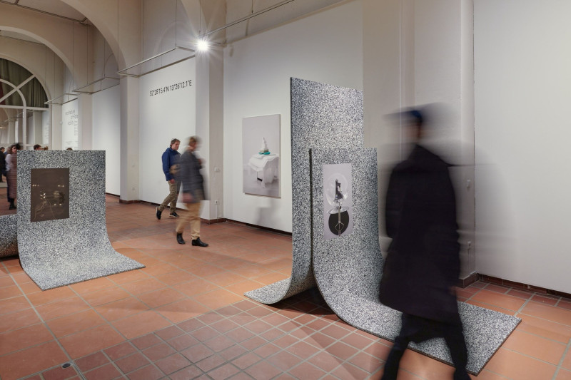 Interior of the Galerie im Körnerpark with visitors, sculptures on the floor, and artworks on the walls