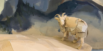 Ein Schaf aus Pappe steht auf einem Felsen aus Pappmaché.