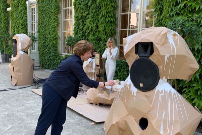 Die Künstlerin bemalt die Pappe, die um die Lautsprecher gebaut wurden