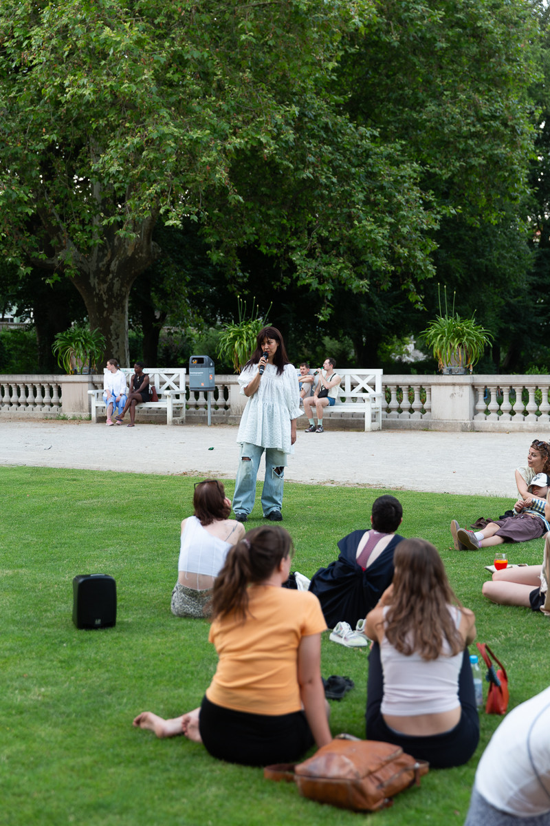 text: >
  Künstlerin spricht zu einer Gruppe von
  Besuchern, die auf einer Wiese im Park
  sitzen
decorative: false
source: reviewed