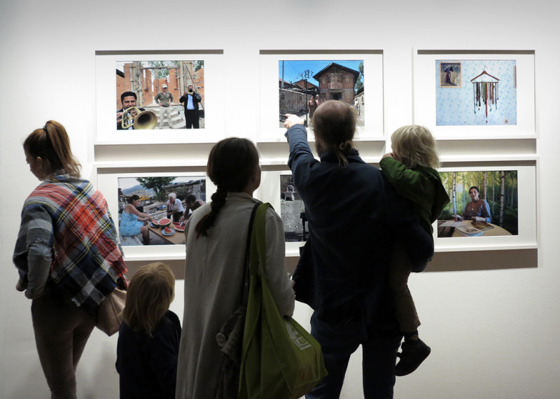 Visitors look at the photos on the wall