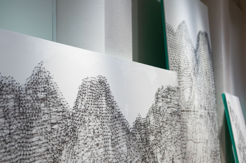 Large white canvases with nails and threads connecting the dots.
