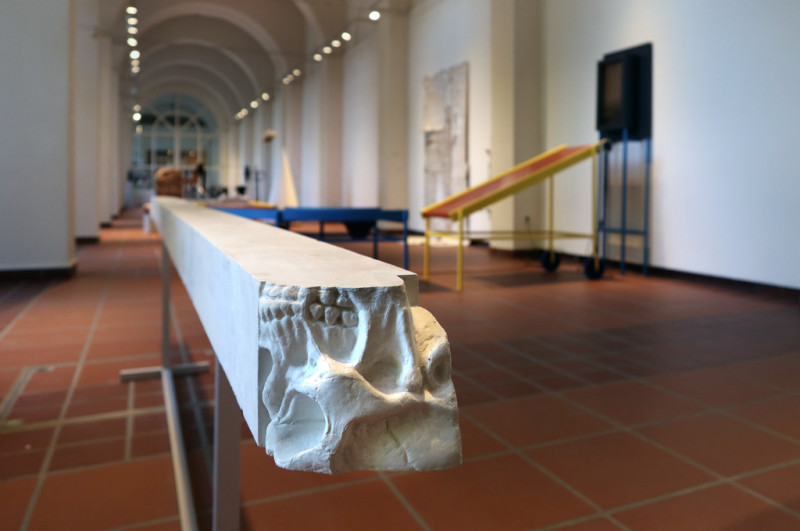 Im Raum ist eine Gipsstange waagerecht aufgestellt. An deren Ende erkennt man den Abdruck eine Schädels.