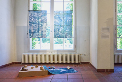 An arrangement of ceramic objects and fabric on a rectangular block