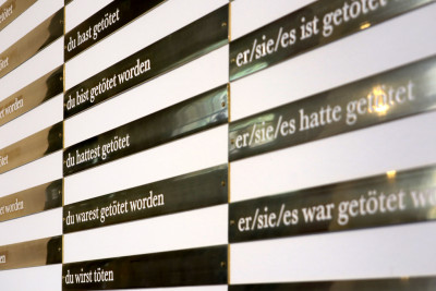 A number of slim brass plates on which conjugations of the German verb 'töten' (to kill) can be read.