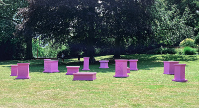 Several pink pedestals stand on a meadow
