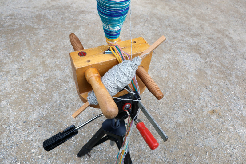Nahaufnahme der Spindel mit verschiedenen bunten Fadenrollen.