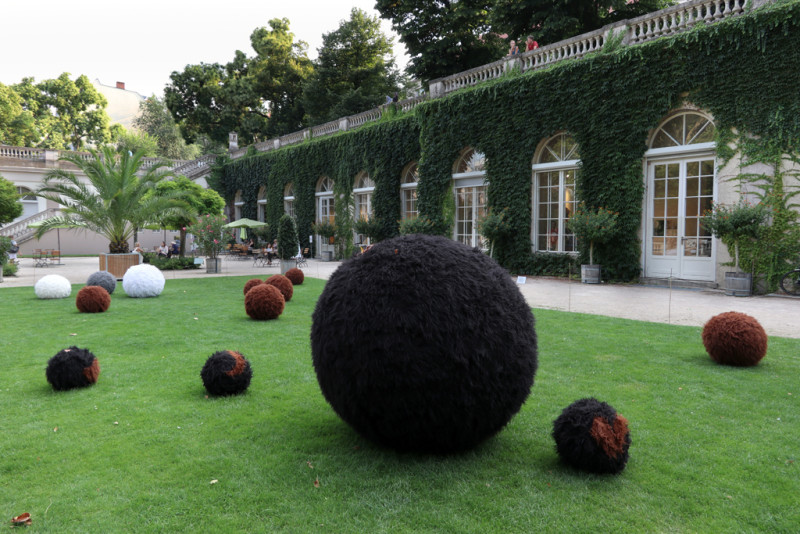 Mit Fell überzogene Bälle liegen auf der Wiese vor der Galerie im Körnerpark