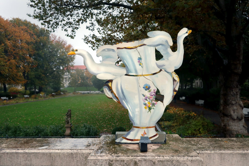 Auf der Balustrade der Terasse des Körnerparks sieht man eine weiße Keramikvase aus Pappe mit zwei Schweinen
