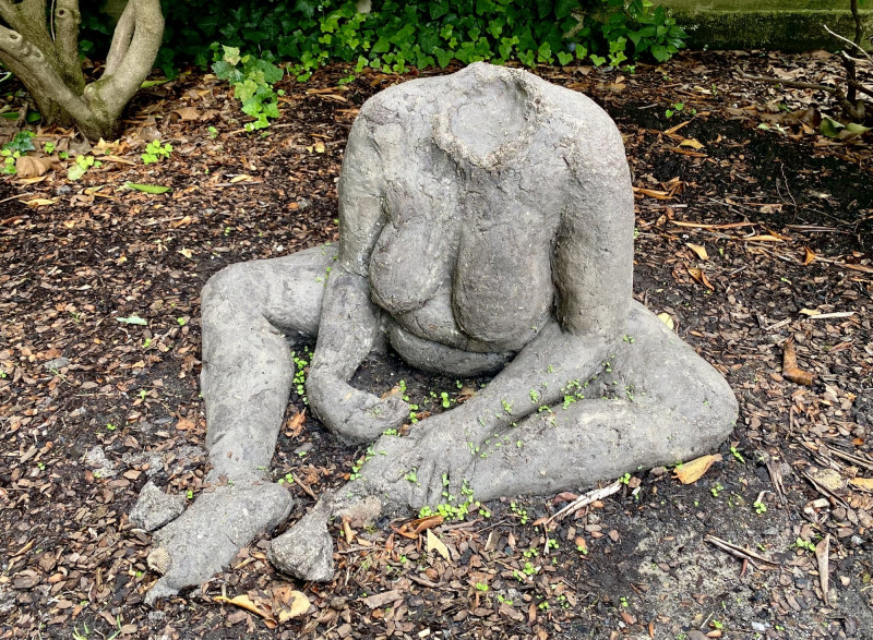 Skulptur eines weibliche Körpers in einer gekauerten Sitzposition