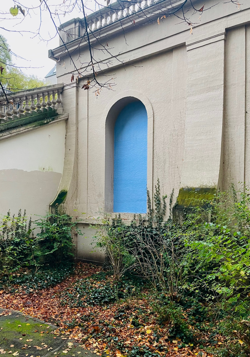 Im Körnerpark sind blaue Plakate in den Arkaden der Wand plakatiert.