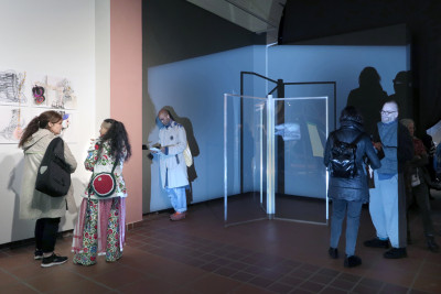 People in the exhibition space in front of artworks