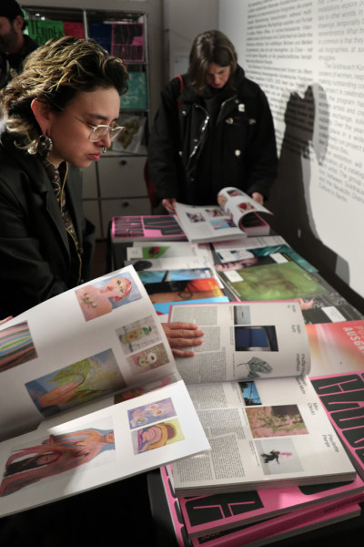 Personen schauen durch den Ausstellungskatalog durch