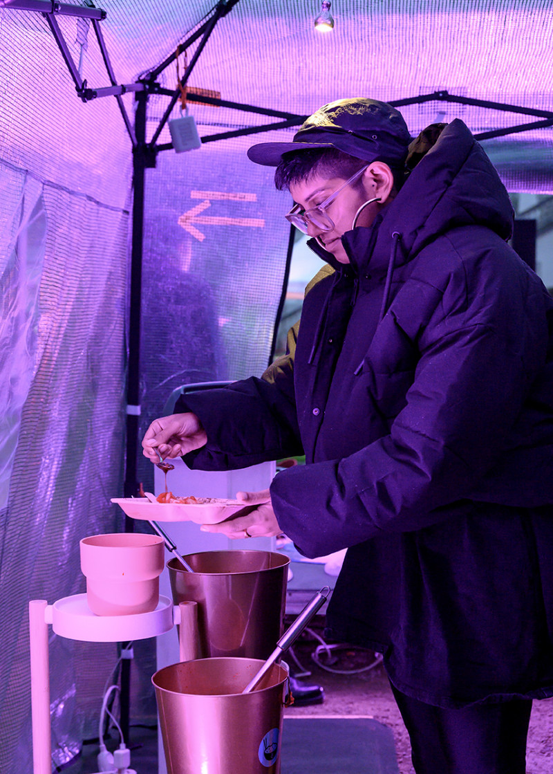Visitor fills up food during anniversary opening with participatory cooking and eating performance