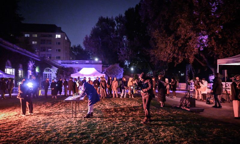 Lalo Gomes von dem Kollektiv LaLoVe’s Kitchen serviert den Geburtstagskuchen, während um ihn herum die Besuchende versammelt sind