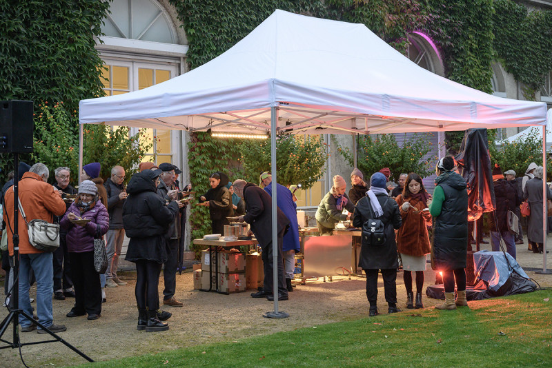 Besuchende versammeln sich gemeinsam um die performative Essstation