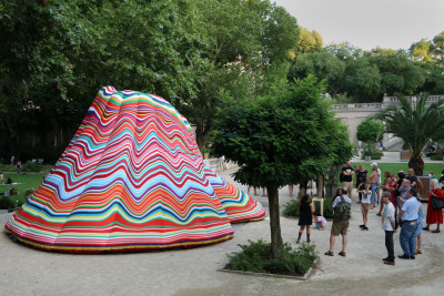 Ein bunter aufgeblasener Vulkan steht im Körnperk und Besuchenden stehen darum herum